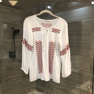 White blouse with blue/orange stitching